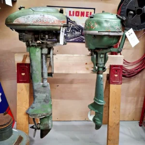 Pair of vintage green outboard boat motors, including a classic Firestone model, mounted on a wooden display stand.