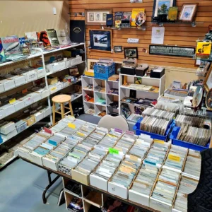 Extensive collection of vintage postcards and paper ephemera organized in boxes on tables and shelves in an antique booth.