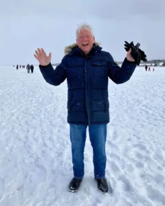 A joyful photo of Henry Jones with his arms raised on an ice-covered Lake Simcoe.