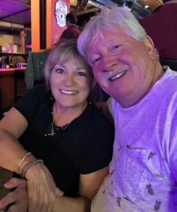 Henry Jones and Jackie at a social venue with vibrant purple lighting, both smiling for the camera.
